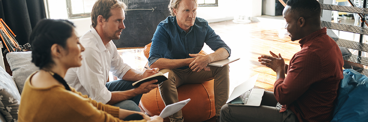 Employee explaining the benefits of Xerox DocuShare Flex App to three other employees