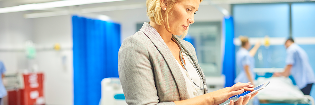 Healthcare professional using a tablet to view patient information with a Xerox healthcare app